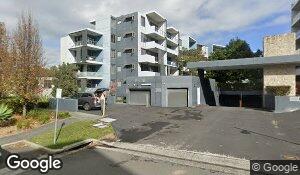 Street-level exterior of the Epping Park apartment complex, with stacked balconies and shared vehicle access. This is the building exterior, not a view inside Unit 371. 371/5 Epping Park Drive, Epping, NSW.
