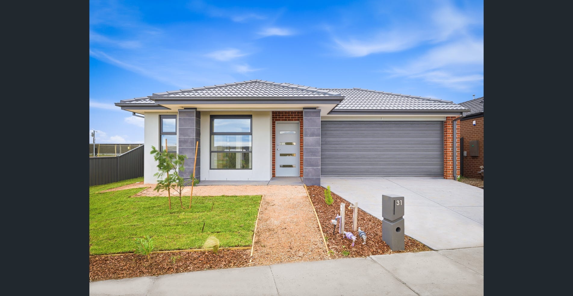 A single-storey home with a double garage, driveway and a small front lawn. 31 Tuff Street, Werribee, VIC.